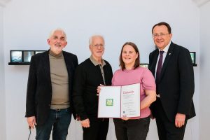 Museumsleuter Thomas Pulle, Ausstellungskurator Ernest A. Kienzl und Bürgermeister Matthias Stadler gratulieren Evi Leuchtgelb zum Adolf Peschek-Preis der Jury 2025